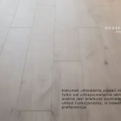 Jasne panele podłogowe ułożone wzdłuż pomieszczenia. Wskazówki jak kłaść panele: kierunek zależy od wielkości pokoju i preferencji.