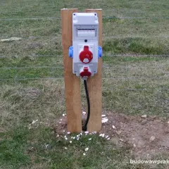 Skrzynka elektryczna na działce, gotowa do podłączenia narzędzi. Co dalej? Zasilanie dla Twoich projektów ogrodowych.
