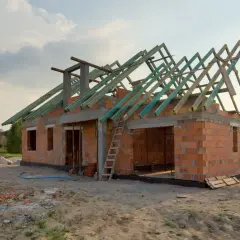 Budowa garażu bez pozwolenia 70m2. Dom w stanie surowym, z widoczną konstrukcją dachu.