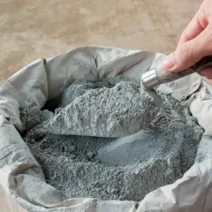 Łopata nabiera suchy beton pod kostkę. Kluczowe są odpowiednie proporcje, by uzyskać trwałą nawierzchnię.