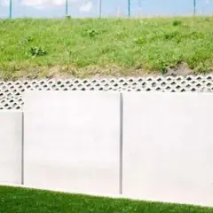 Solidny mur oporowy z betonowych płyt, nad nim ażurowa warstwa i zielone zbocze. Kara za mur oporowy? Raczej solidna konstrukcja.