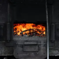 Płonące drewno w piecu. Warto wiedzieć, do kiedy można palić węglem, by uniknąć problemów.