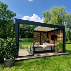 Nowoczesny podest tarasowy montaż na trawie. Szklana pergola z wygodną sofą w otoczeniu zieleni.