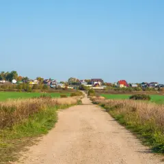 Droga gruntowa prowadzi do osiedla domków jednorodzinnych. Minimalna szerokość drogi dojazdowej do posesji jest wystarczająca dla pojazdów.