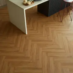 Drewnopodobne panele winylowe ułożone we wzór jodełki. Pokazują, jak układać panele winylowe, tworząc elegancką podłogę w kuchni.