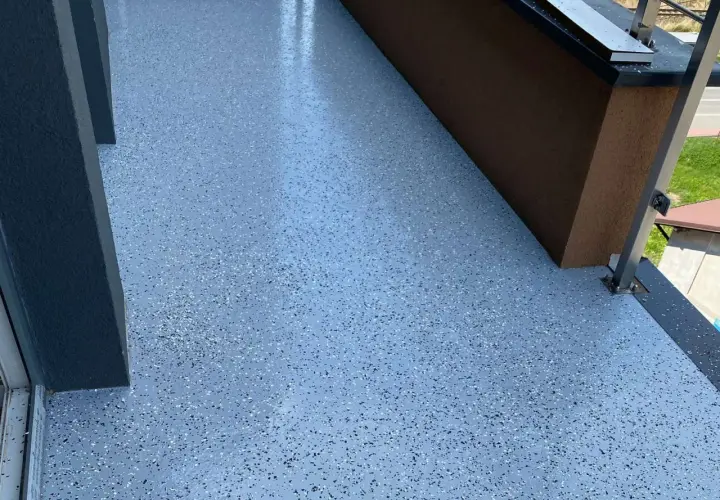 Nowoczesna posadzka żywiczna do garażu, z drobnym, wielokolorowym gresem, nadaje przestrzeni estetyczny i trwały wygląd.