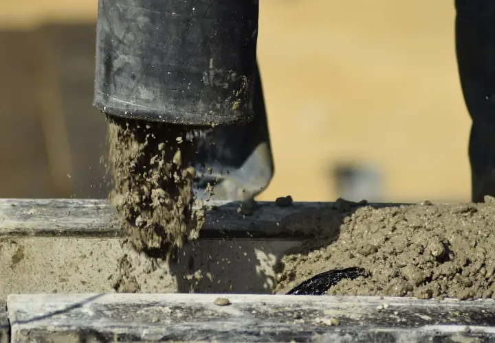 Beton wylewany z czarnej rury. Zastanawiasz się, ile schnie beton w temperaturze 5 stopni? Czekamy na odpowiedź.