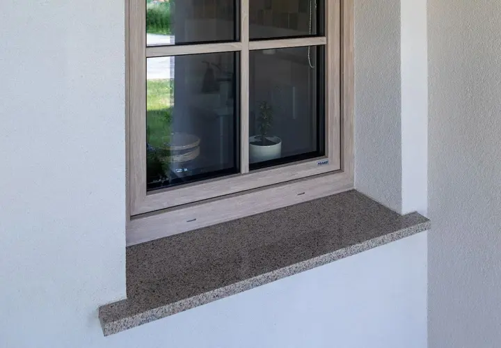 Zewnętrzny parapet z granitu wystaje ok. 5 cm, zapewniając ochronę i estetykę okna.