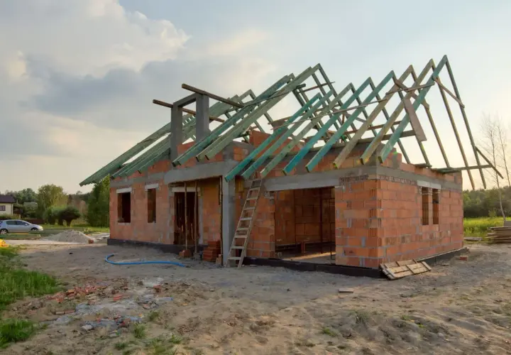 Budowa garażu bez pozwolenia 70m2. Dom w stanie surowym, z widoczną konstrukcją dachu.