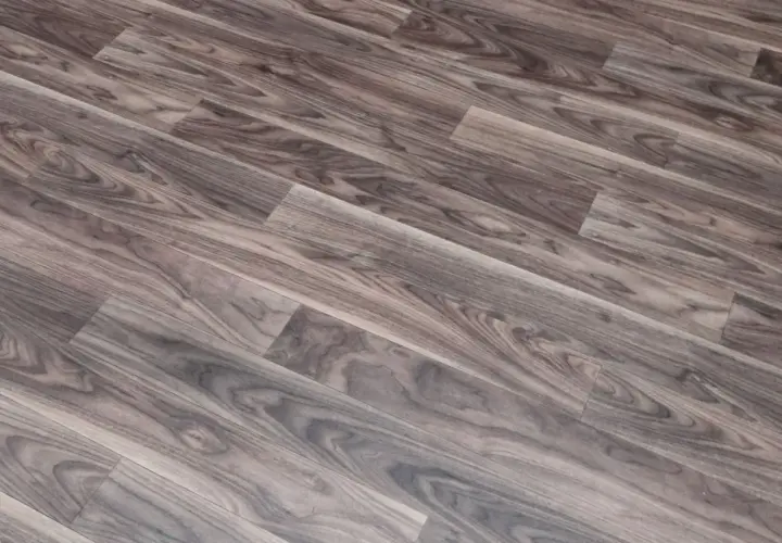Szare linoleum na balkon, imitujące drewno, z widocznym usłojeniem. Idealne do stworzenia przytulnej przestrzeni.