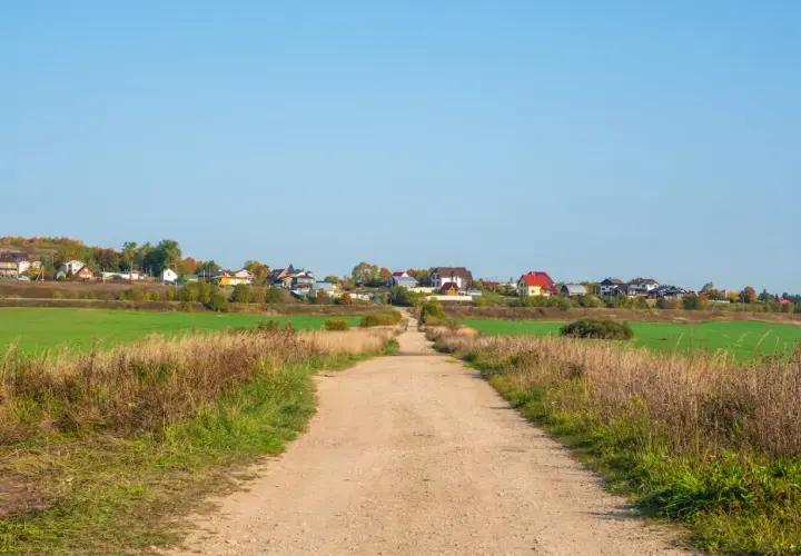 Droga gruntowa prowadzi do osiedla domków jednorodzinnych. Minimalna szerokość drogi dojazdowej do posesji jest wystarczająca dla pojazdów.