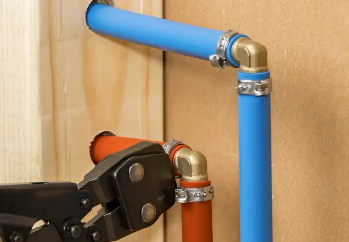 Instalator wykonuje przejście z rury stalowej na pex, używając specjalistycznych narzędzi.
