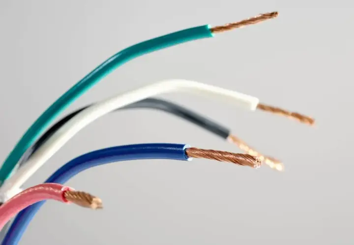 Kolorowe przewody elektryczne, każdy z odsłoniętym miedzianym rdzeniem. Widać oznaczenie prądu L na niebieskim kablu.