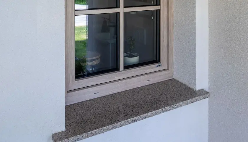Zewnętrzny parapet z granitu wystaje ok. 5 cm, zapewniając ochronę i estetykę okna.