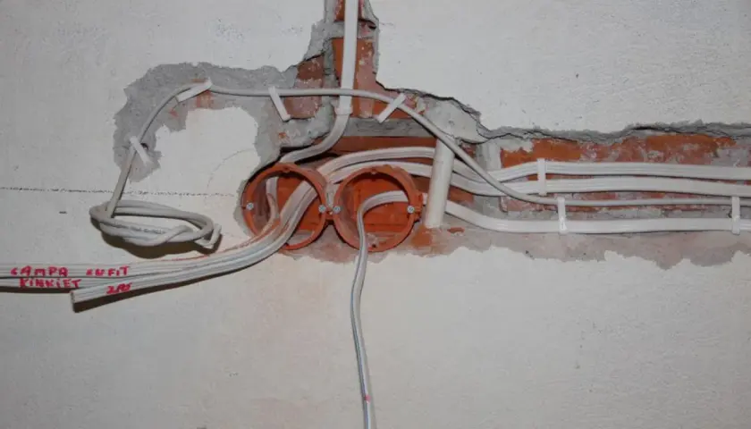 Widoczne przewody i puszki elektryczne, część starej instalacji elektrycznej.