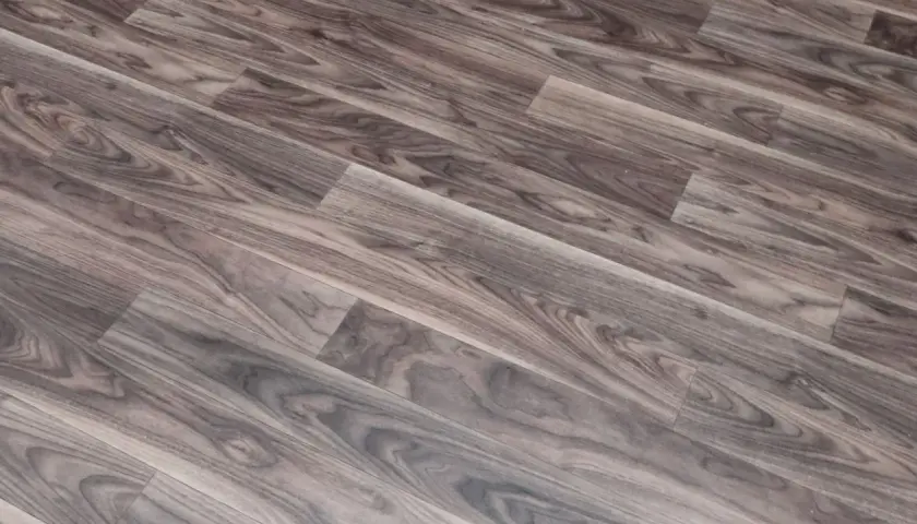 Szare linoleum na balkon, imitujące drewno, z widocznym usłojeniem. Idealne do stworzenia przytulnej przestrzeni.