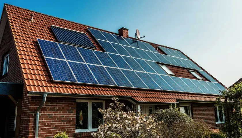 Dom z panelami fotowoltaicznymi na dachu. Instalacja fotowoltaika na starych zasadach, czerpiąca energię ze słońca.