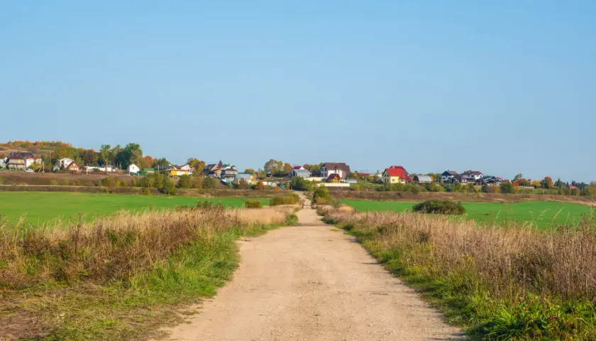 Droga gruntowa prowadzi do osiedla domków jednorodzinnych. Minimalna szerokość drogi dojazdowej do posesji jest wystarczająca dla pojazdów.