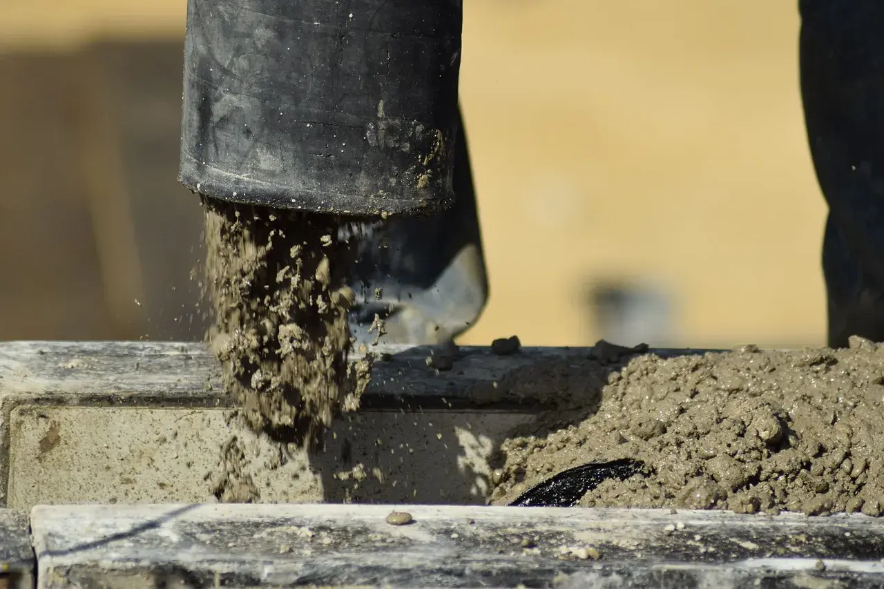 Beton wylewany z czarnej rury. Zastanawiasz się, ile schnie beton w temperaturze 5 stopni? Czekamy na odpowiedź.