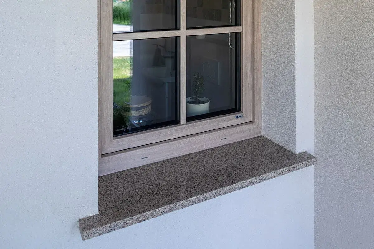 Zewnętrzny parapet z granitu wystaje ok. 5 cm, zapewniając ochronę i estetykę okna.