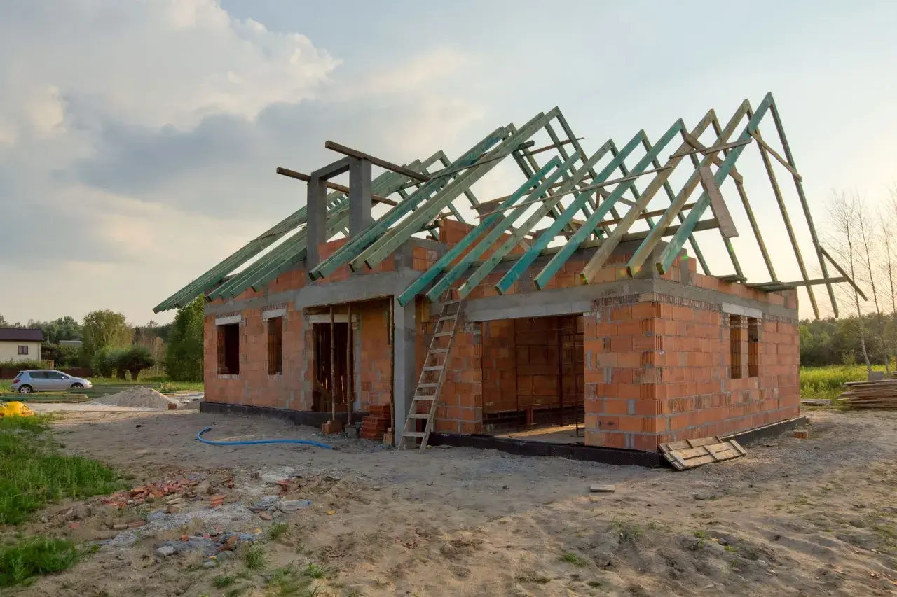 Budowa garażu bez pozwolenia 70m2. Dom w stanie surowym, z widoczną konstrukcją dachu.
