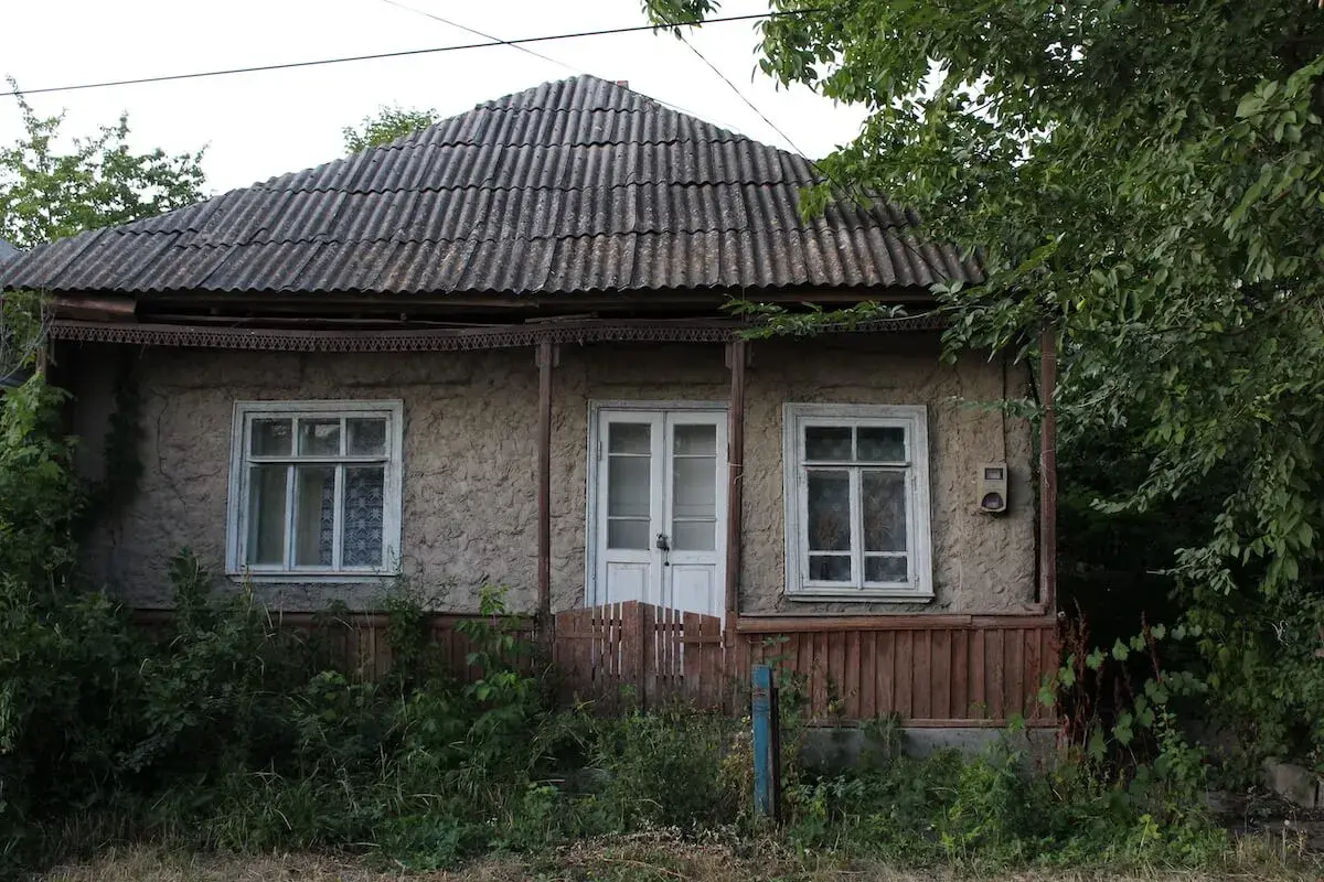 Stary dom z falistym dachem i zarośniętym ogrodem. Jak zrobić odbiór domu po 20 latach?