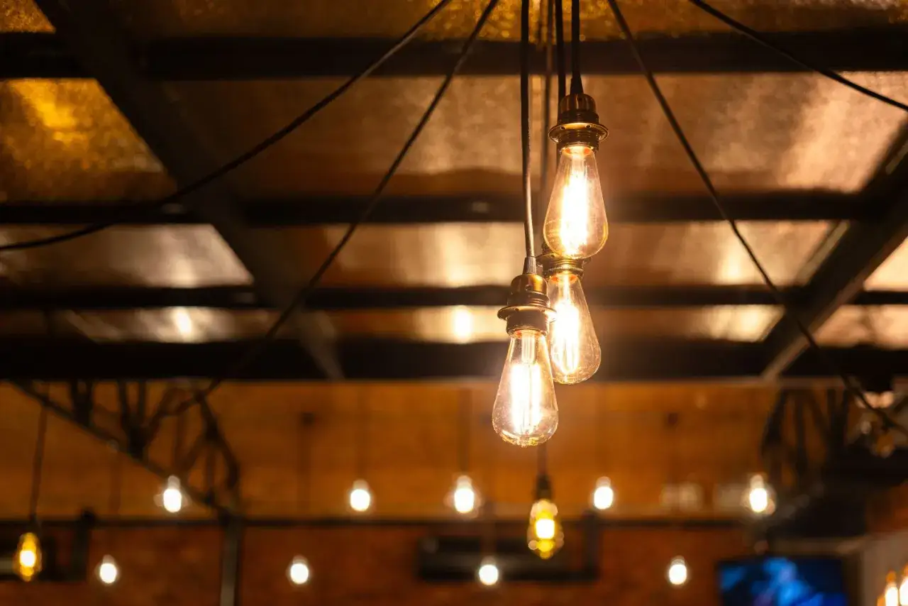 Trzy żarówki Edisona wiszące na przewodach tworzą klimatyczną instalację elektryczną natynkową.