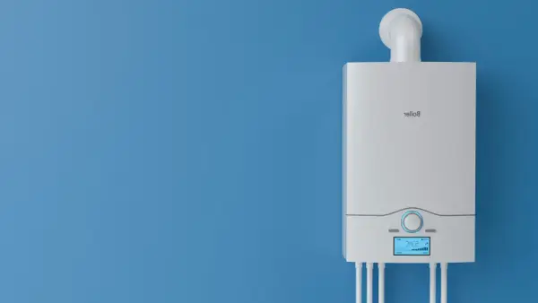 Nowy, biały piec gazowy na niebieskiej ścianie. Dowiedz się, jak wyłączyć piec gazowy na lato, aby zaoszczędzić energię.